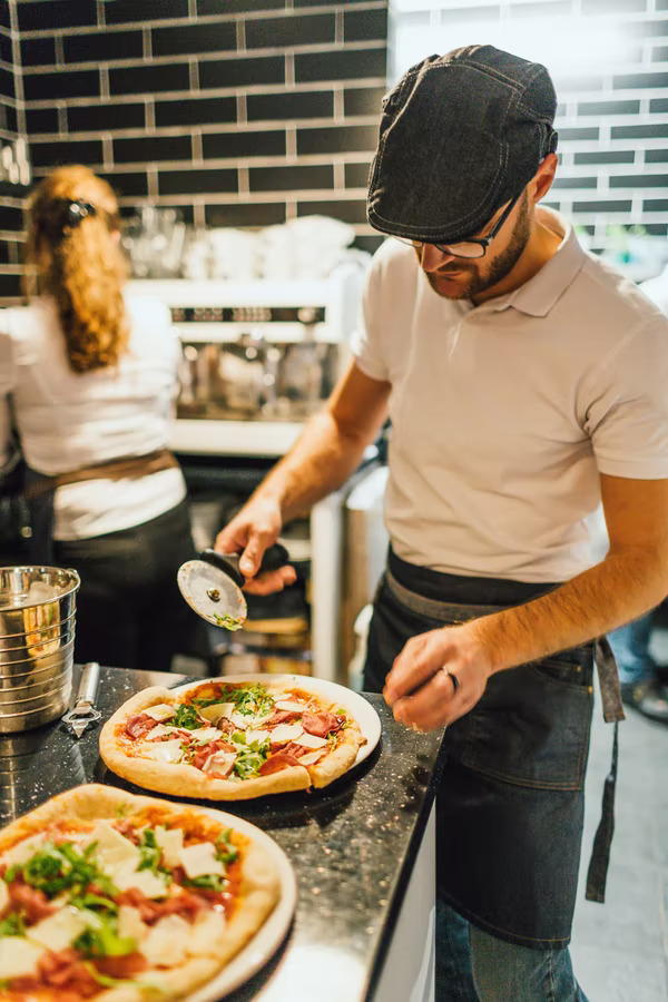 Marco cutting pizza to serve